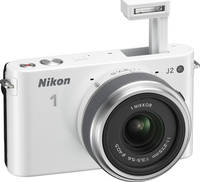 Nikon 1 J2 in weiß mit Nikkor 11-275 und Blitz von vorne rechts