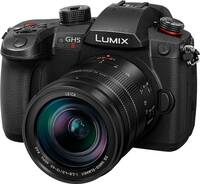 Panasonic Lumix DC-GH5 II in schwarz mit DG Vario 12-60mm f28-40 von schräg vorne links
