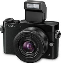 Panasonic Lumix DMC-GM5 in schwarz mit G Vario 12-32 mm und Aufsteckblitz von vorne links
