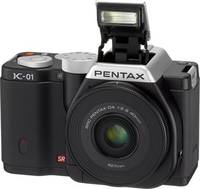 Pentax K-01 in schwarz mit DA 40mm und Blitz von vorne links Pentax K-01 in schwarz mit DA 40mm und Blitz von vorne links